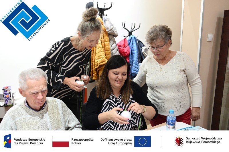 seniorzy pod czujnym okiem instruktora tworzą rękodzieło